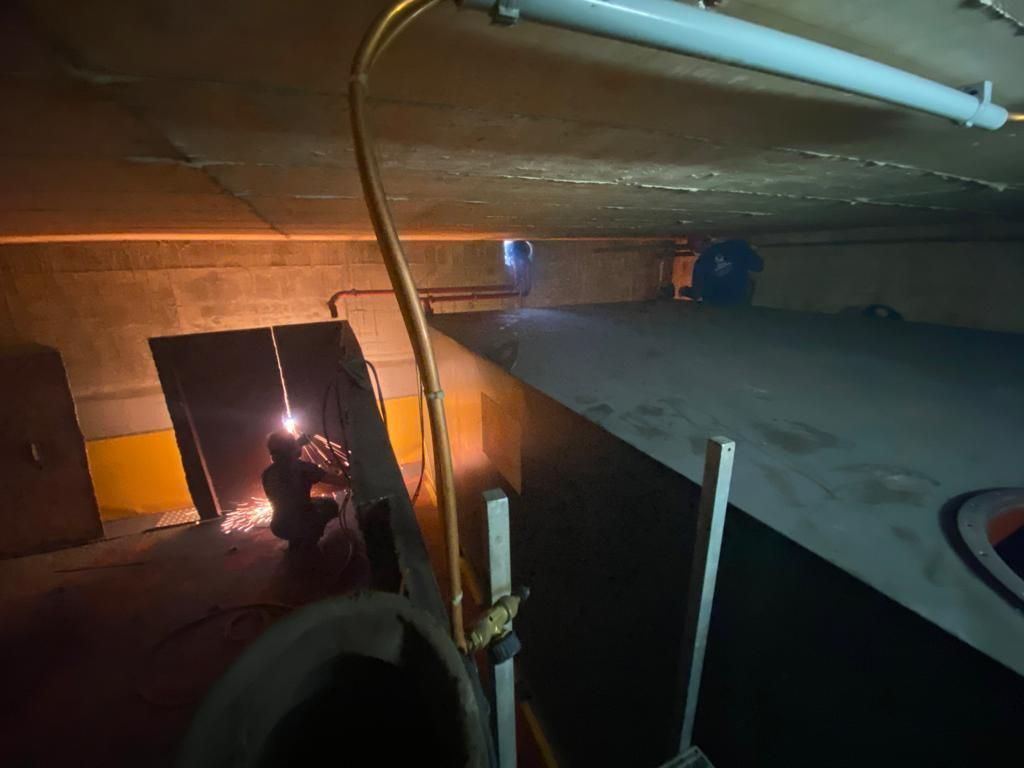 Eine Person schweißt in einem dunklen Raum ein Stück Metall.