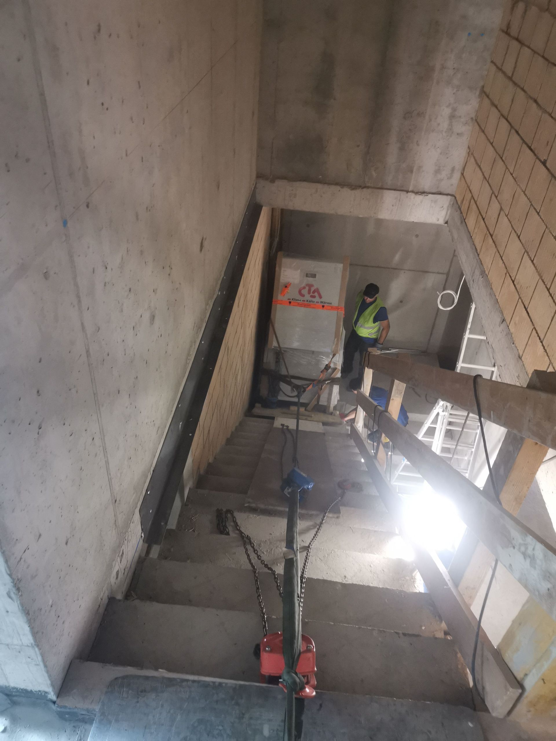 Ein Mann steht auf einer Leiter in einem im Bau befindlichen Gebäude.