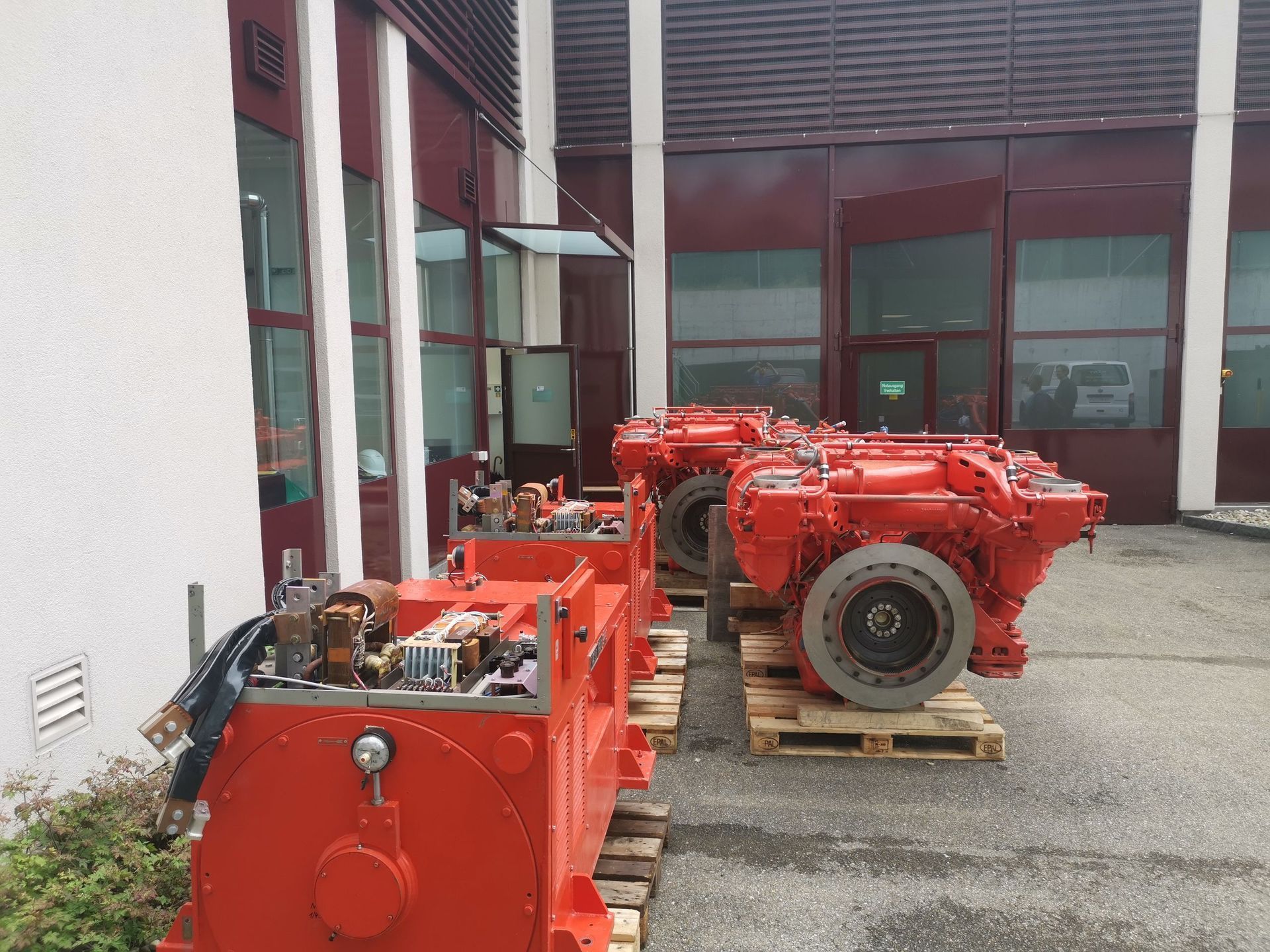 Eine Reihe roter Motoren steht vor einem Gebäude