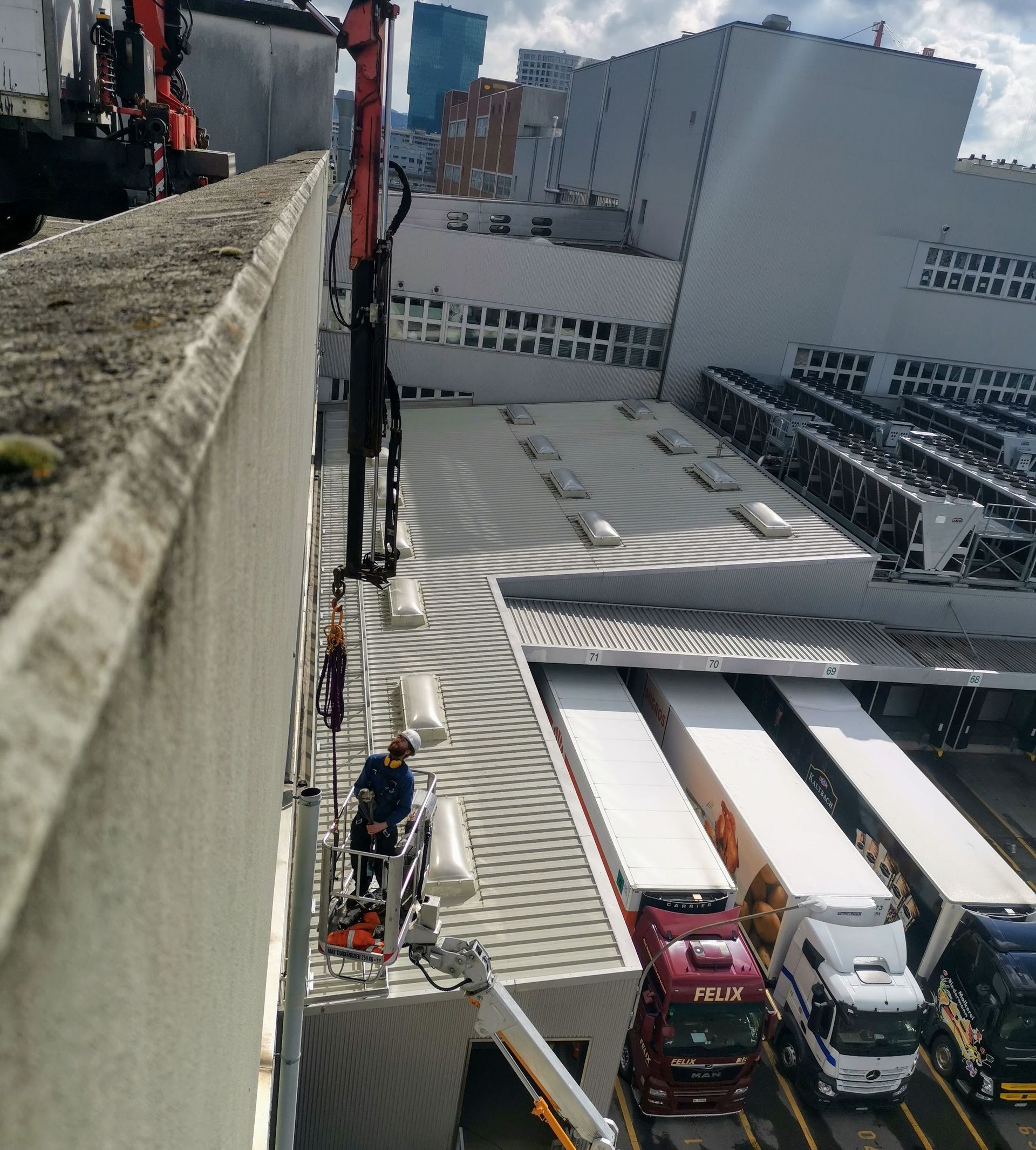 Eine Luftaufnahme eines Gebäudes mit davor geparkten Lastwagen