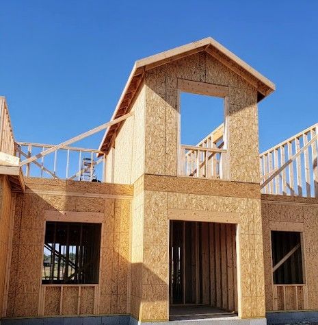 A house under construction with a blue sky in the background
