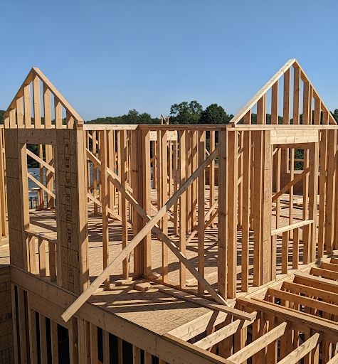 A wooden frame of a house with a blue sky in the background