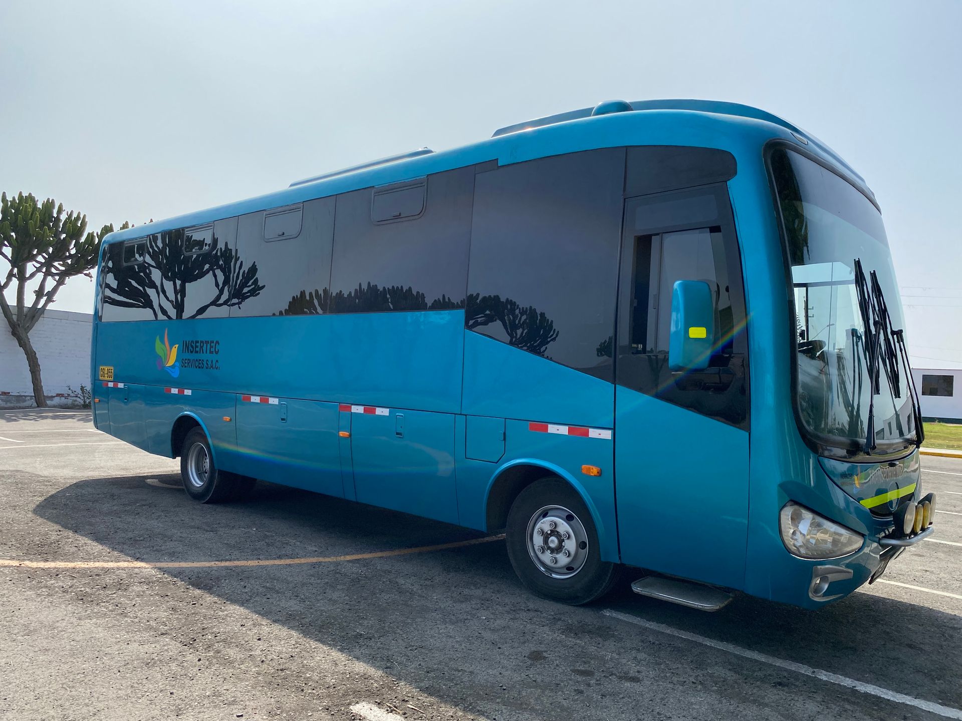 Un autobús azul está estacionado en un estacionamiento.