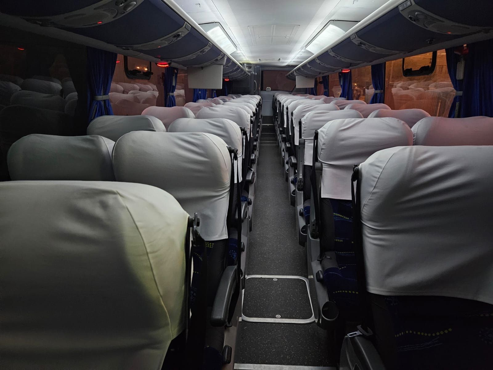 El interior de un autobús con muchos asientos.