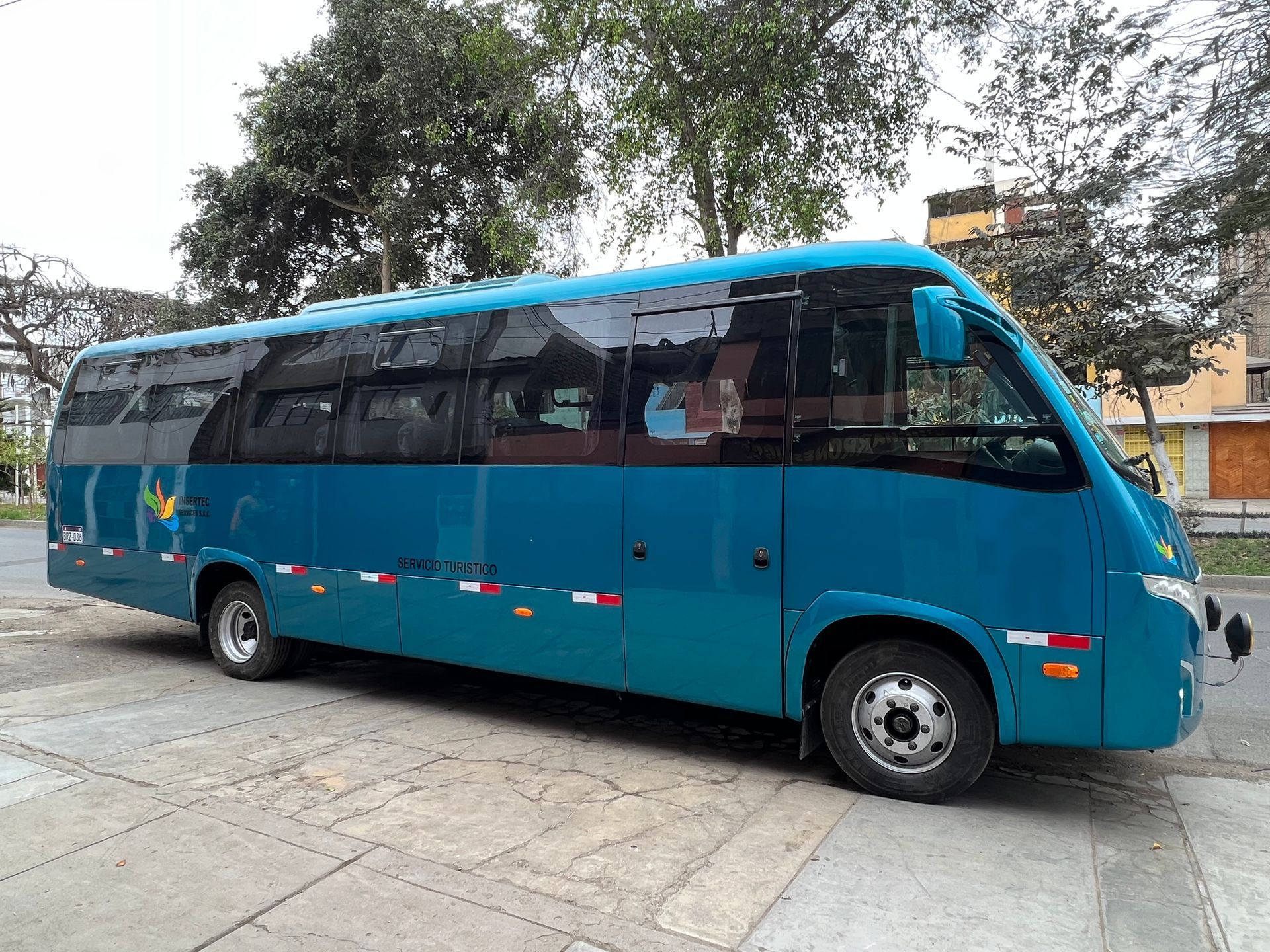 Un autobús azul está estacionado al costado de la carretera.