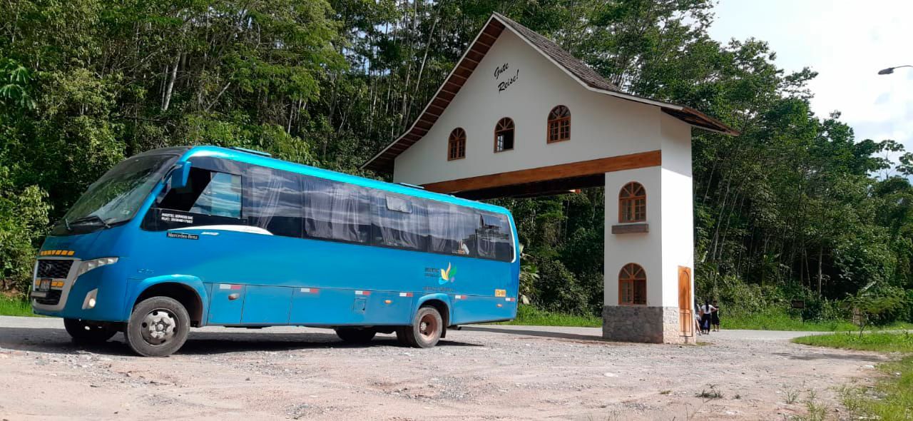 Un autobús azul está estacionado frente a un edificio blanco.