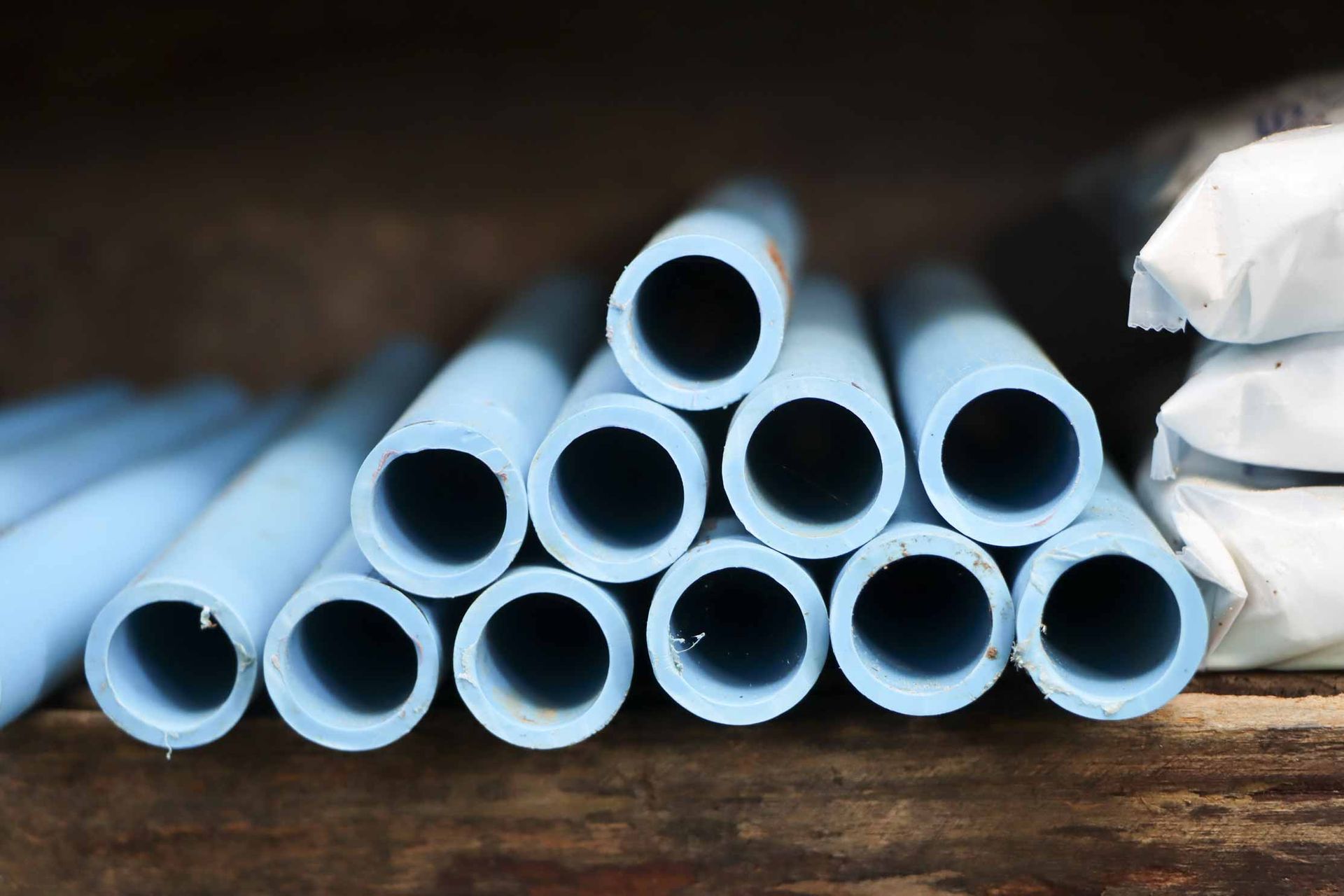 Stack of light blue plastic tubes on a wooden surface