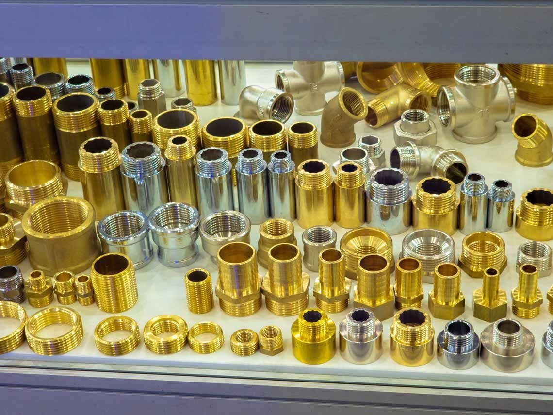 Assorted gold and silver metal fittings and connectors arranged on a surface