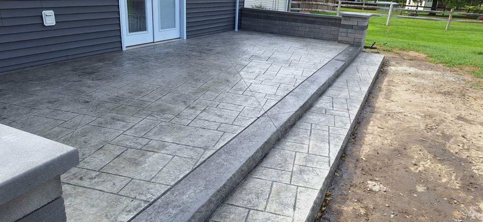 A concrete patio with steps leading up to a house.