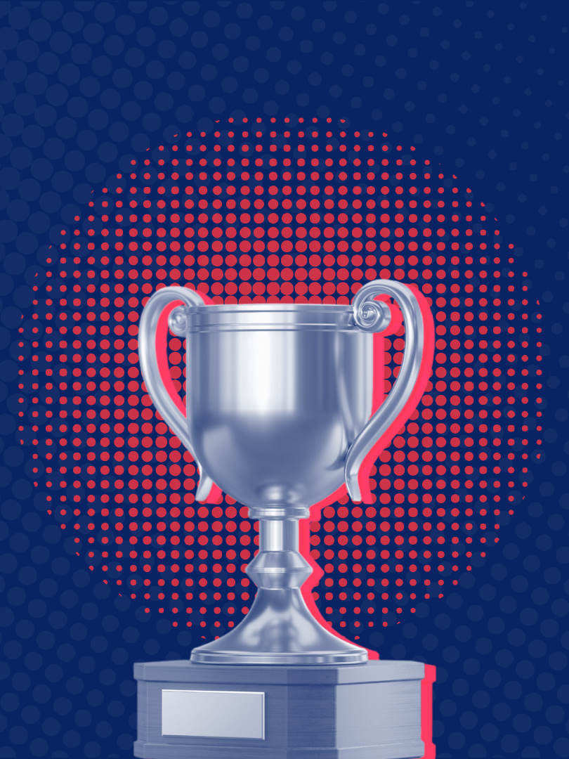 a silver trophy against a blue and red polka dot background