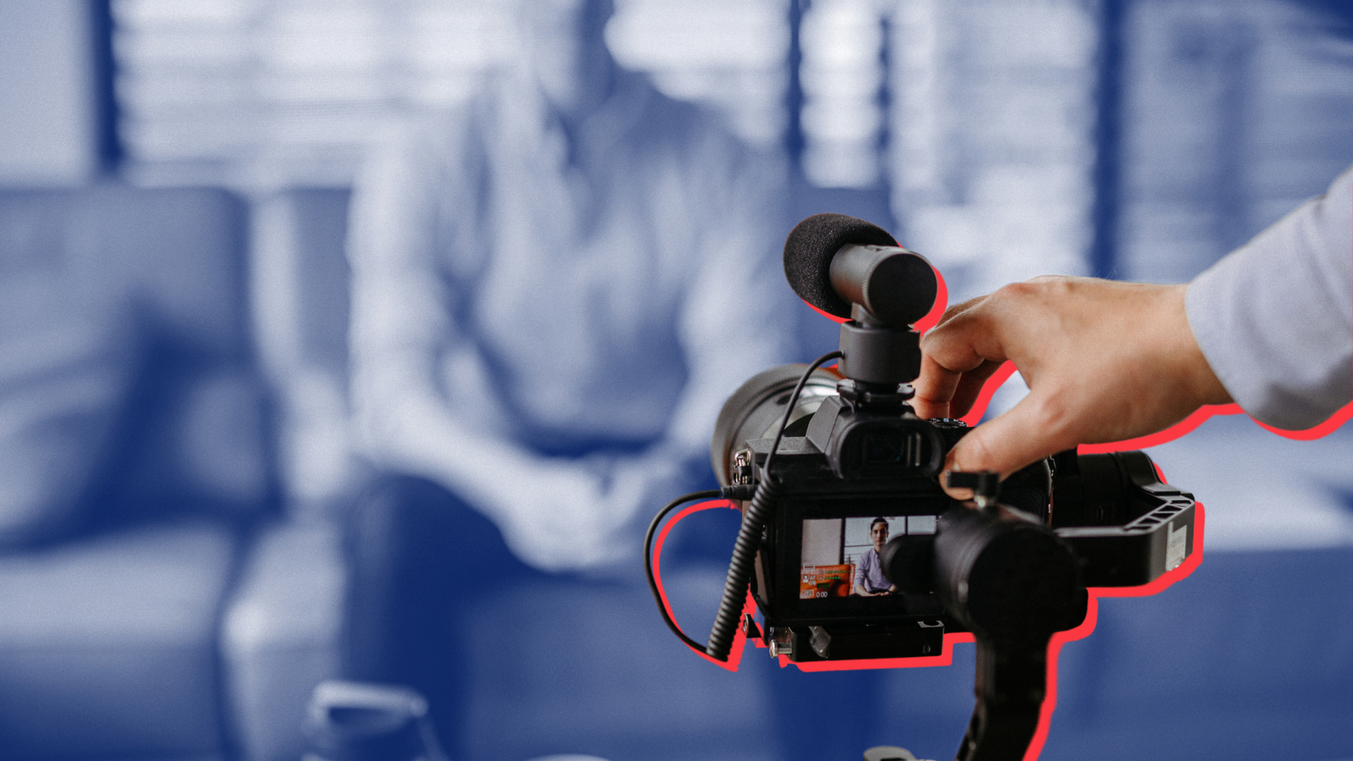 A person is holding a camera with a microphone attached to it.