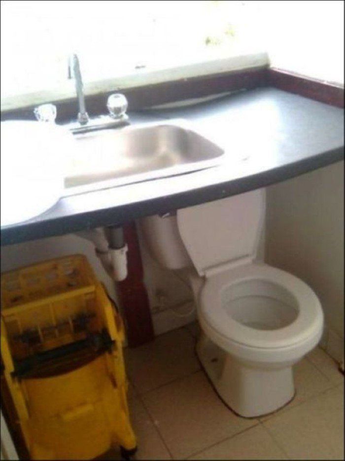 a bathroom with a toilet a sink and a yellow mop
