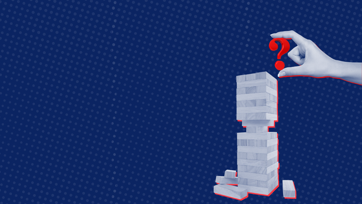 Hand placing red question mark on precarious block tower. Blue background.