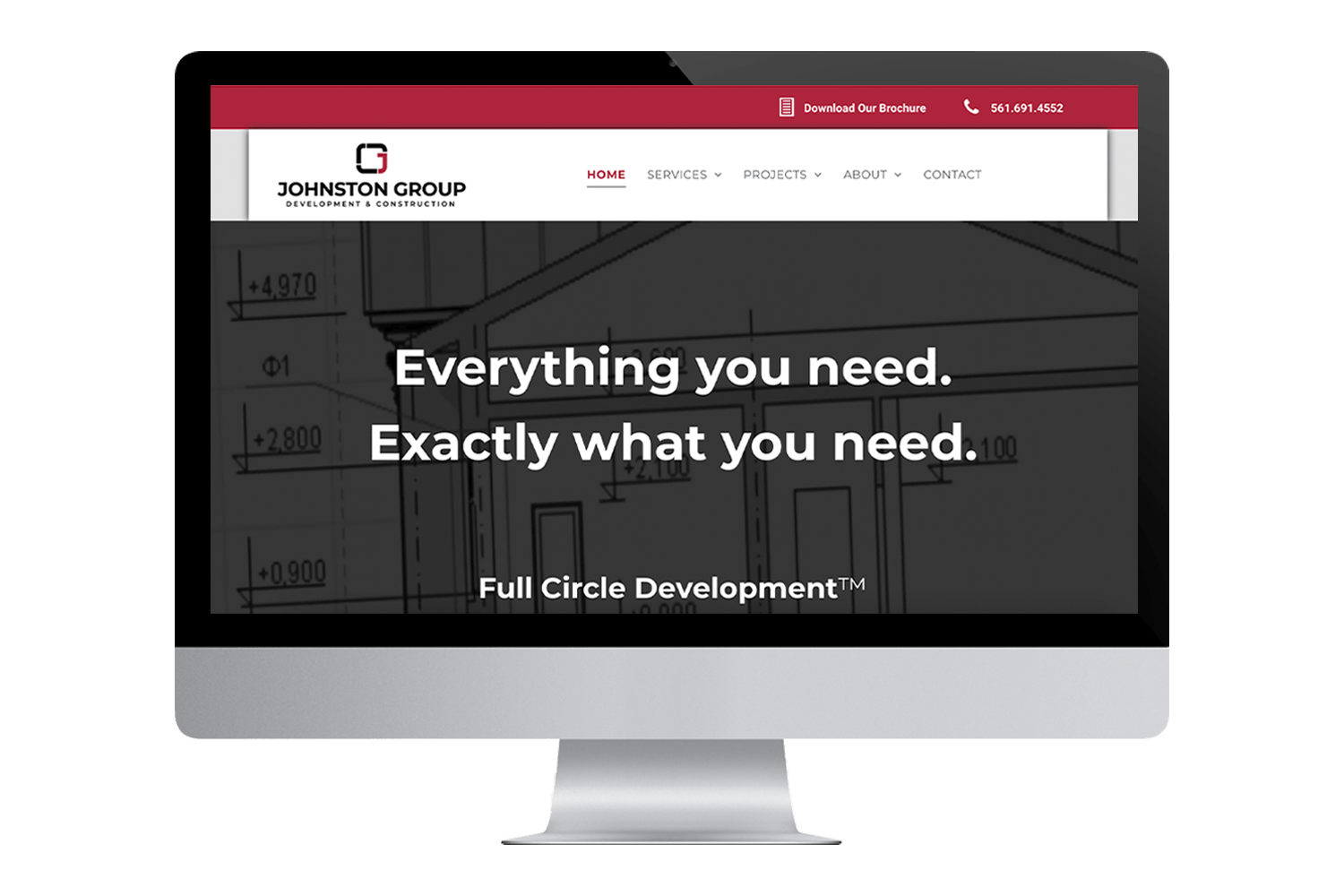 a computer monitor displays a website for johnston group development & construction