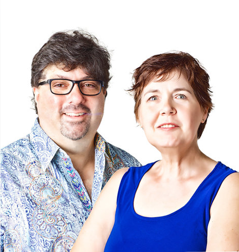 a man and a woman are posing for a picture together . the woman, Kellie McCartney, is wearing a blue tank top.  the man, Bryon McCartney, is wearing a blue dress shirt with a decorative pattern