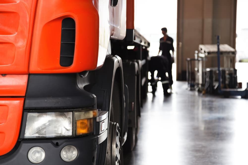 A Man is Working on a Truck in a Garage — Wards Byron Shire Truck & Machinery Centre In Tyagarah, NSW