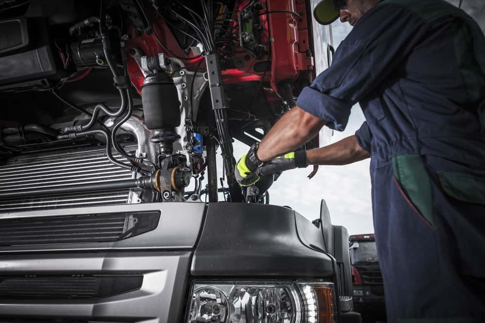 A Man is Working on the Engine of a Truck — Wards Byron Shire Truck & Machinery Centre In Tyagarah, NSW