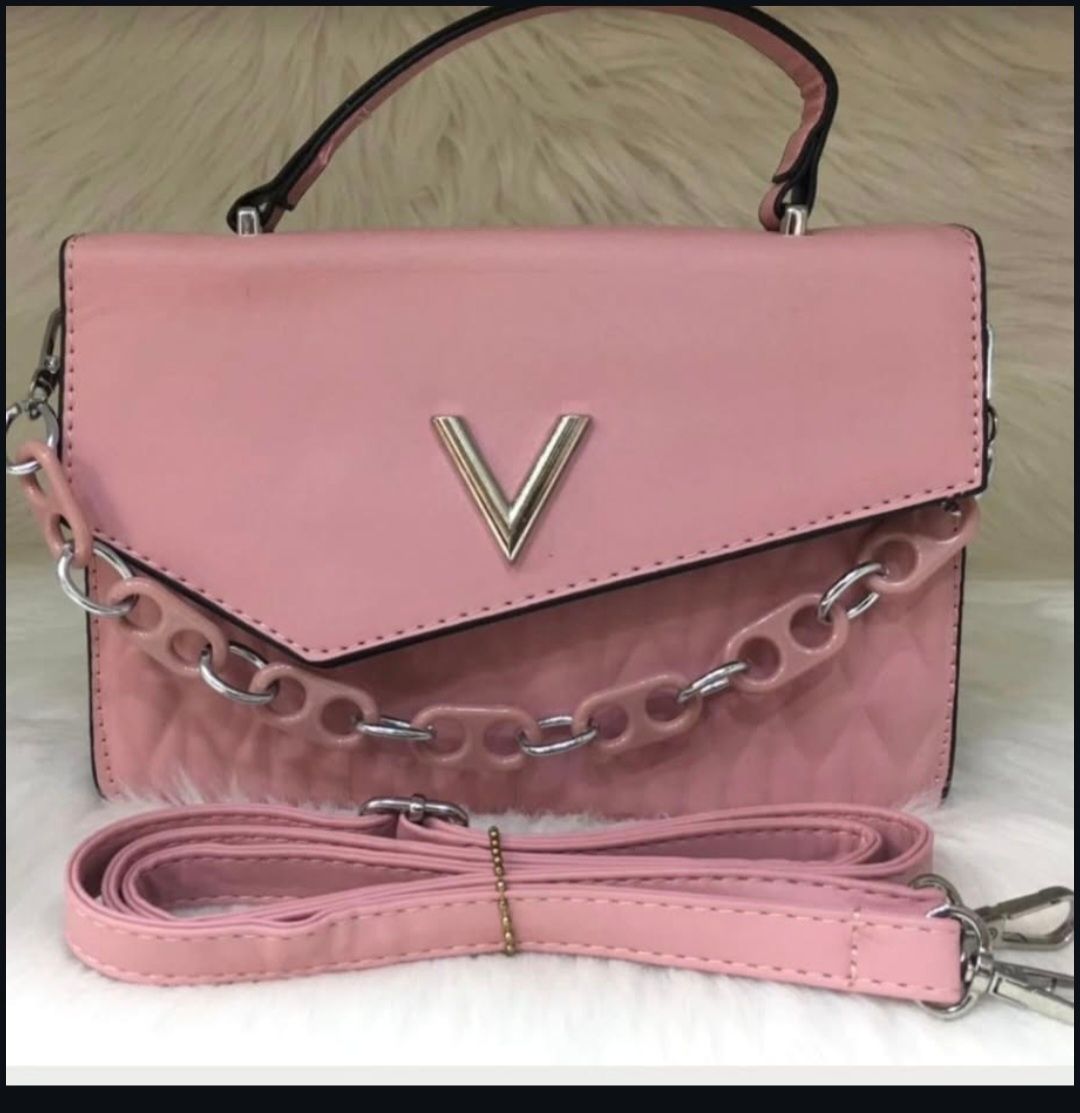 Un bolso rosa con la letra v.