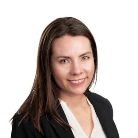 A smiling doctor in a lab coat with a stethoscope around his neck.