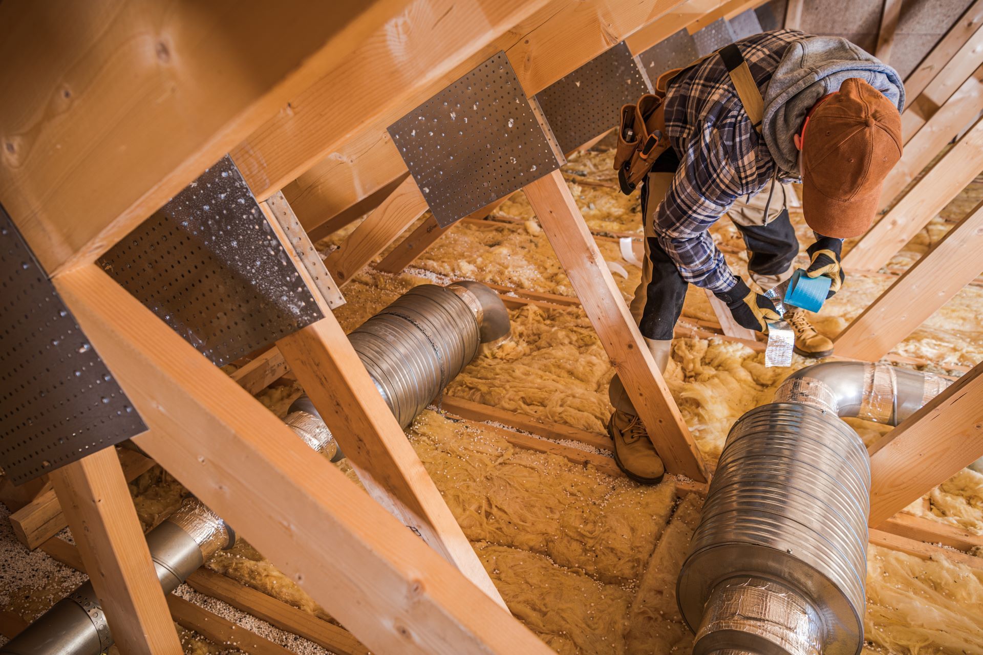 A man is working on the attic of a house.