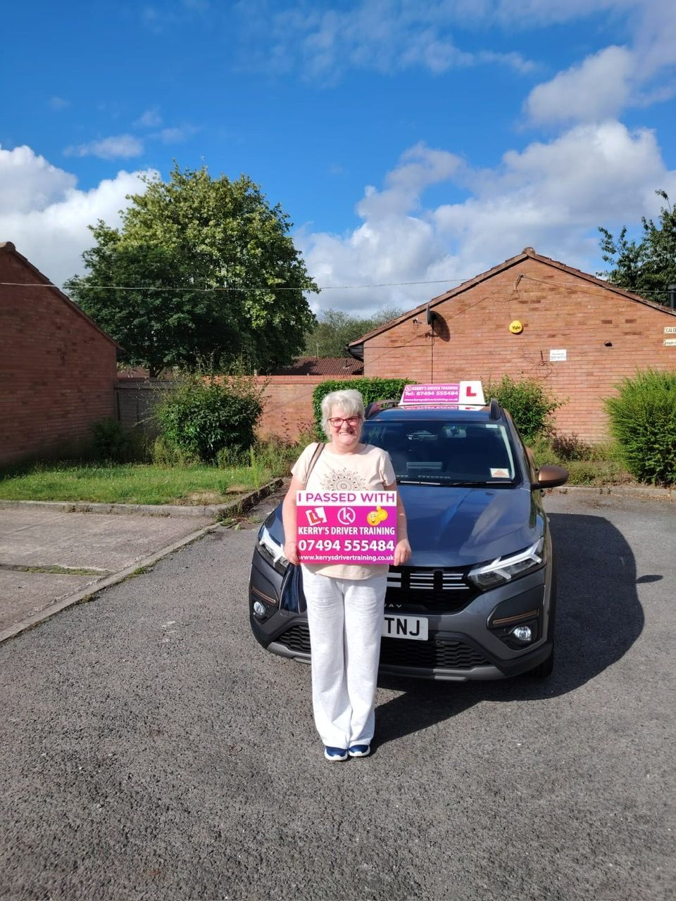 Woman stands in front of a car with 