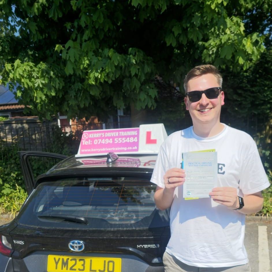 A man is standing in front of a car holding a driving license.