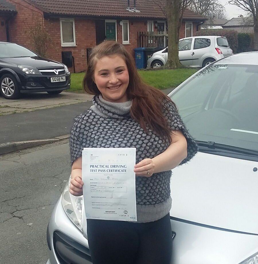 A woman holding a piece of paper that says ' practical driving test pass ' on it