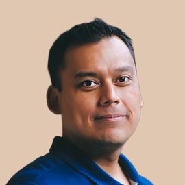 A man in a blue shirt is smiling for the camera