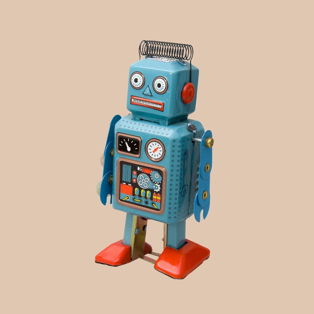a blue toy robot with red feet is standing on a beige background .