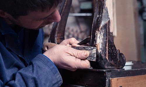 operaio mentre effettua un lavoro di restauro - Larizza restauro mobili a Torino
