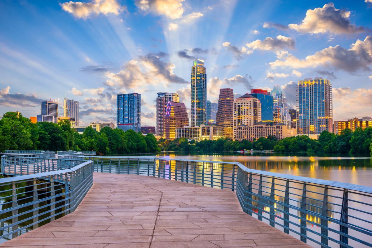 a dock leading to a lake with a city skyline in the background .