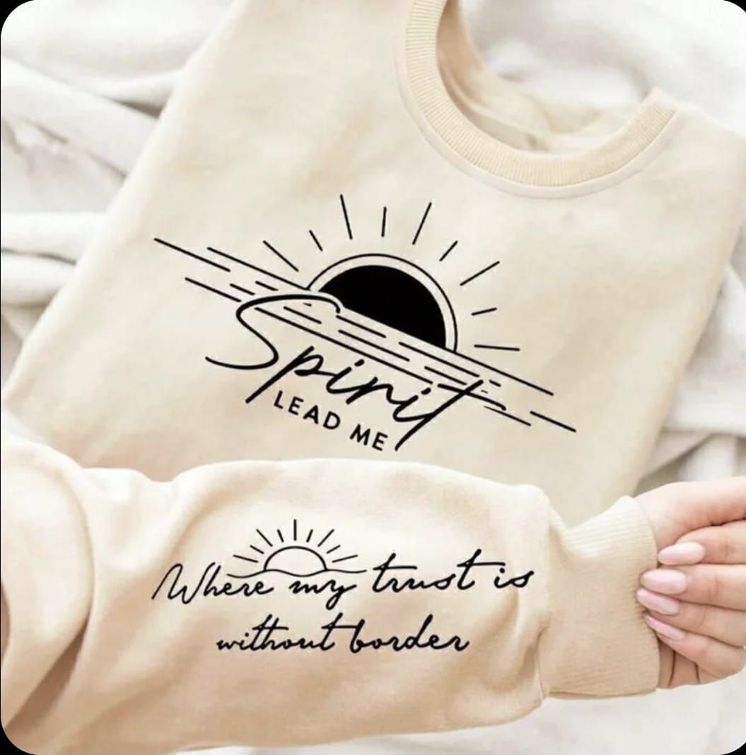 Mujer que lleva una sudadera beige con un diseño de cruz negra y 