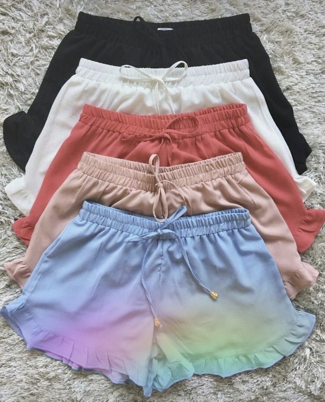 Cinco pares de pantalones cortos en negro, blanco, coral, rosa y azul/violeta degradado