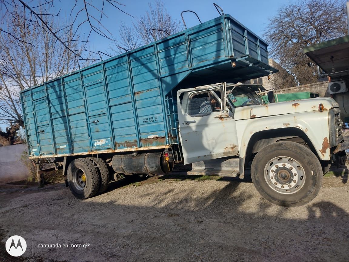 Camioneta vieja, color turquesa y blanca, estacionada en un camino de tierra