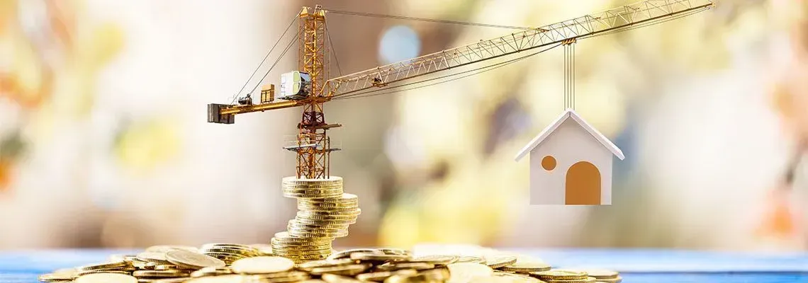 Miniature claw machine gripping a tiny house model over scattered coins, as if plucking a prize from a fantastical construction-themed arcade
