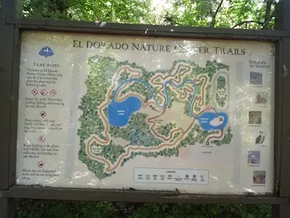 Large educational trail map mounted on a moss-green wall at El Dorado Nature Center, showing winding paths through wetlands and forests