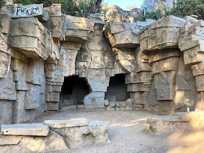 Abandoned animal enclosures and weathered rock formations at the historic Old LA Zoo in golden afternoon light