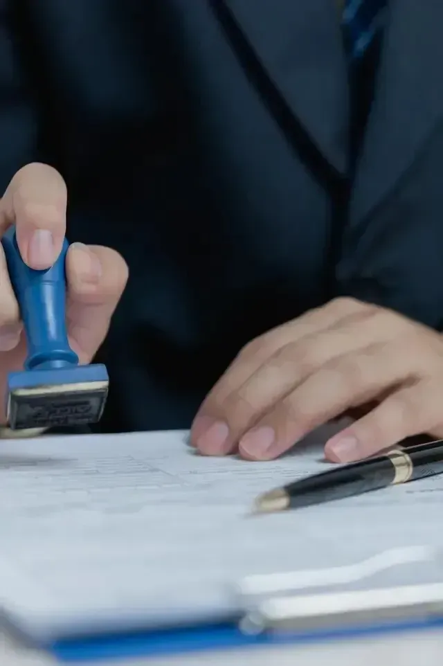 Hard Money Lender Los Angeles - A miniature house sits on paperwork, while a person gestures expressively during a real estate discussion.