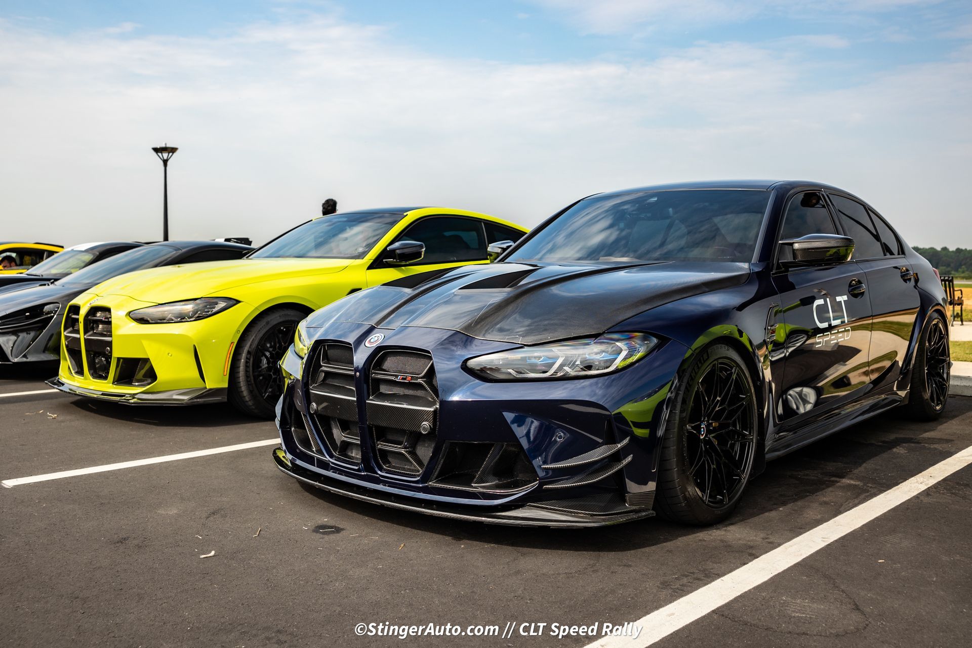 A blue car is parked next to a yellow car in a parking lot