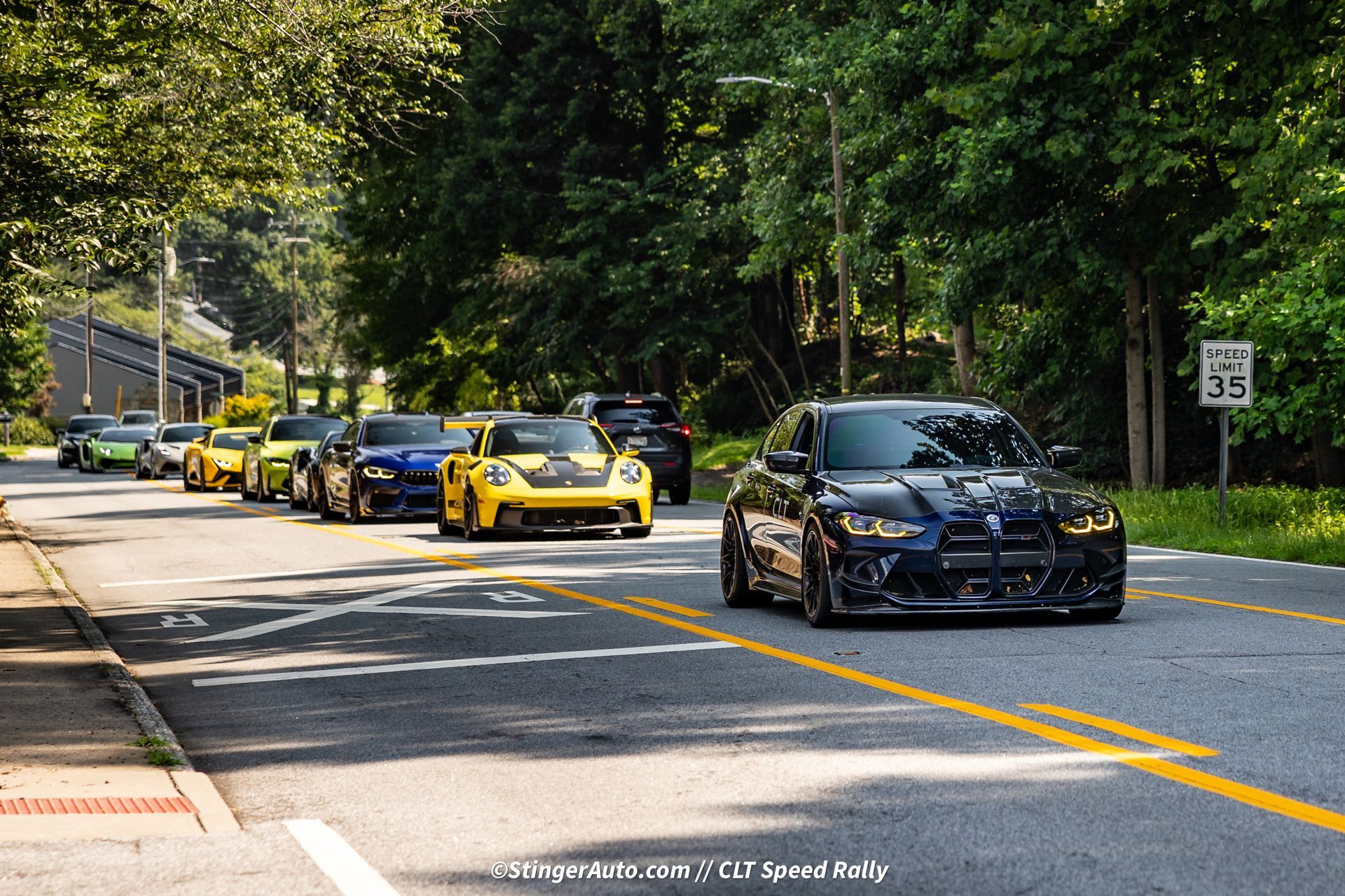 A row of cars are driving down a road