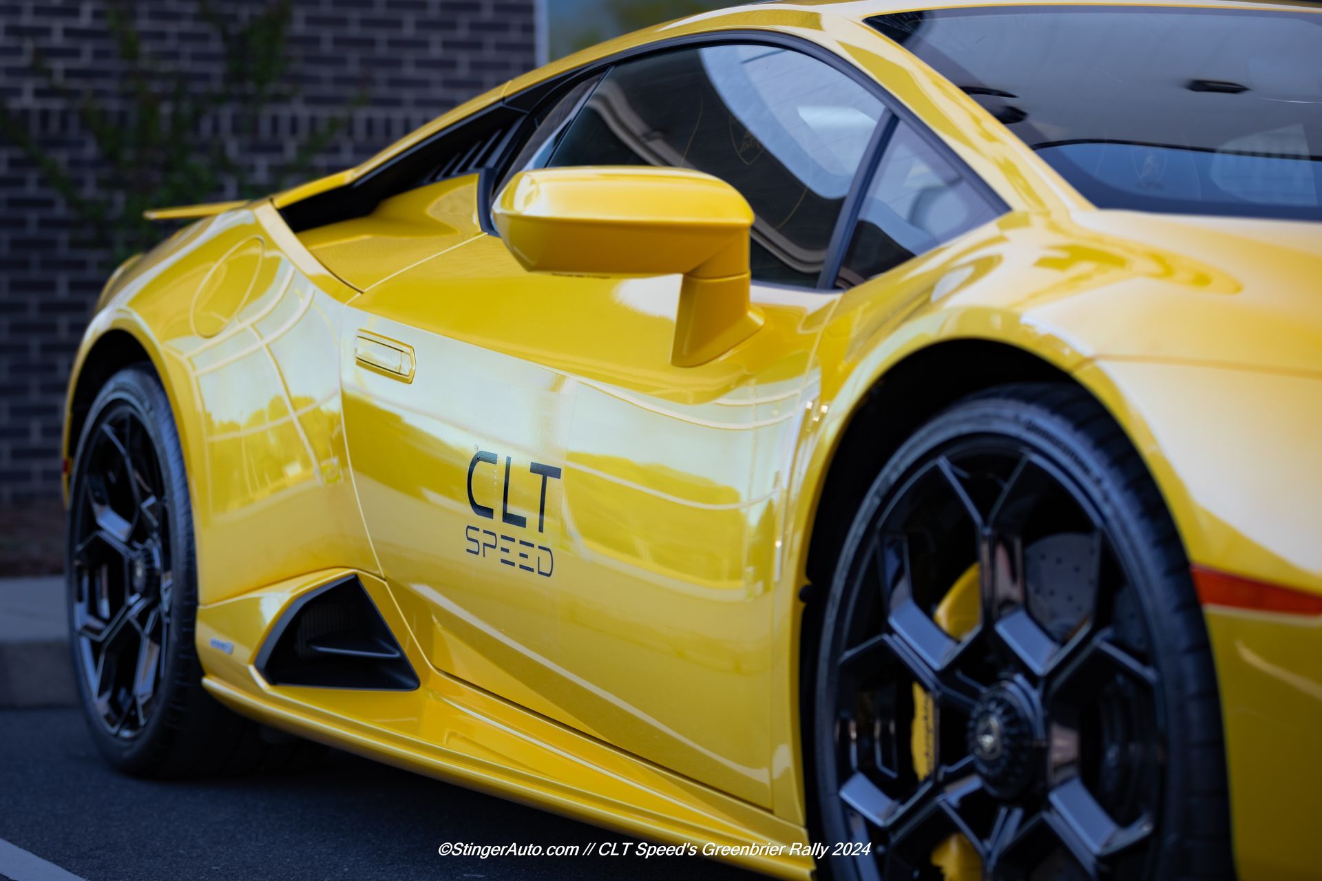 A yellow clt speed car is parked in front of a brick building