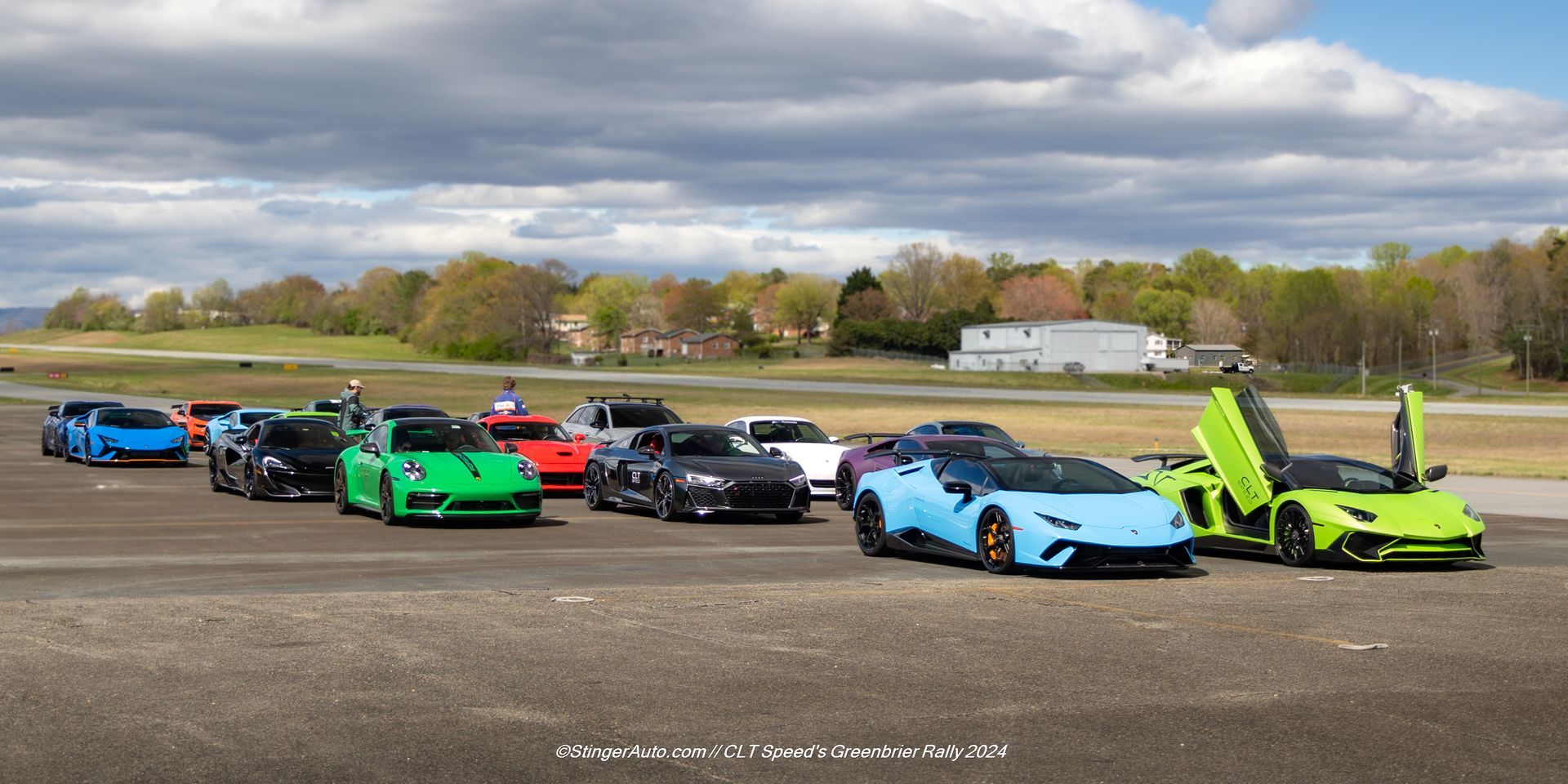 A group of sports cars are parked on a runway