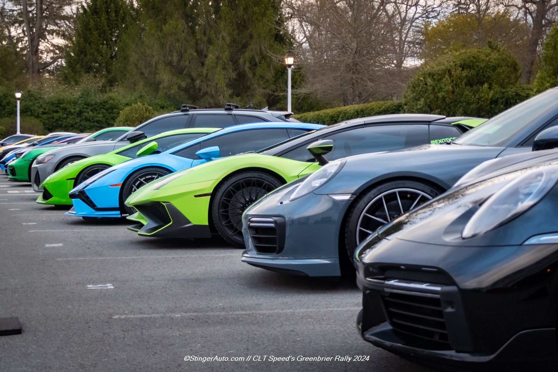 A row of sports cars are parked in a parking lot