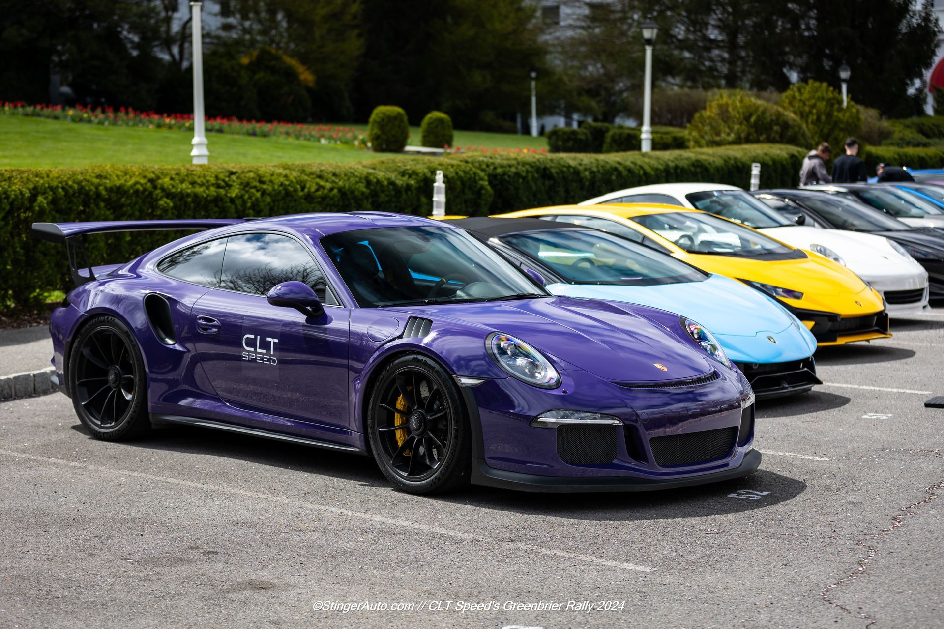 A purple sports car is parked next to other cars