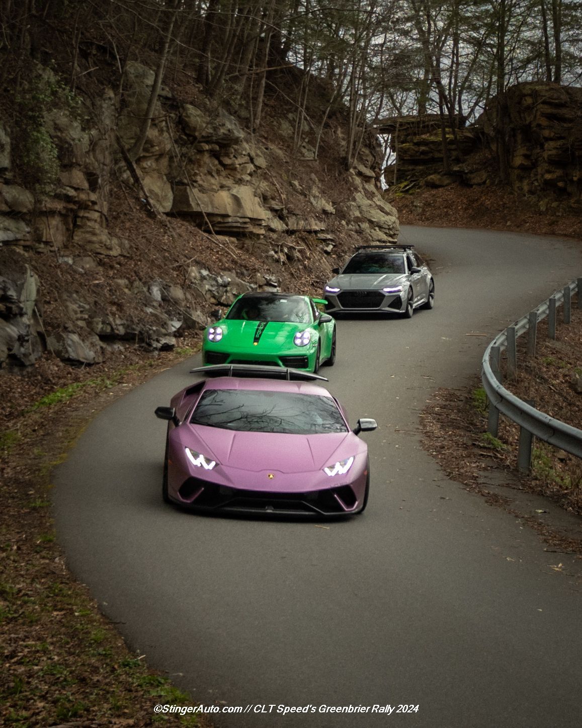 Three sports cars are driving down a curvy road