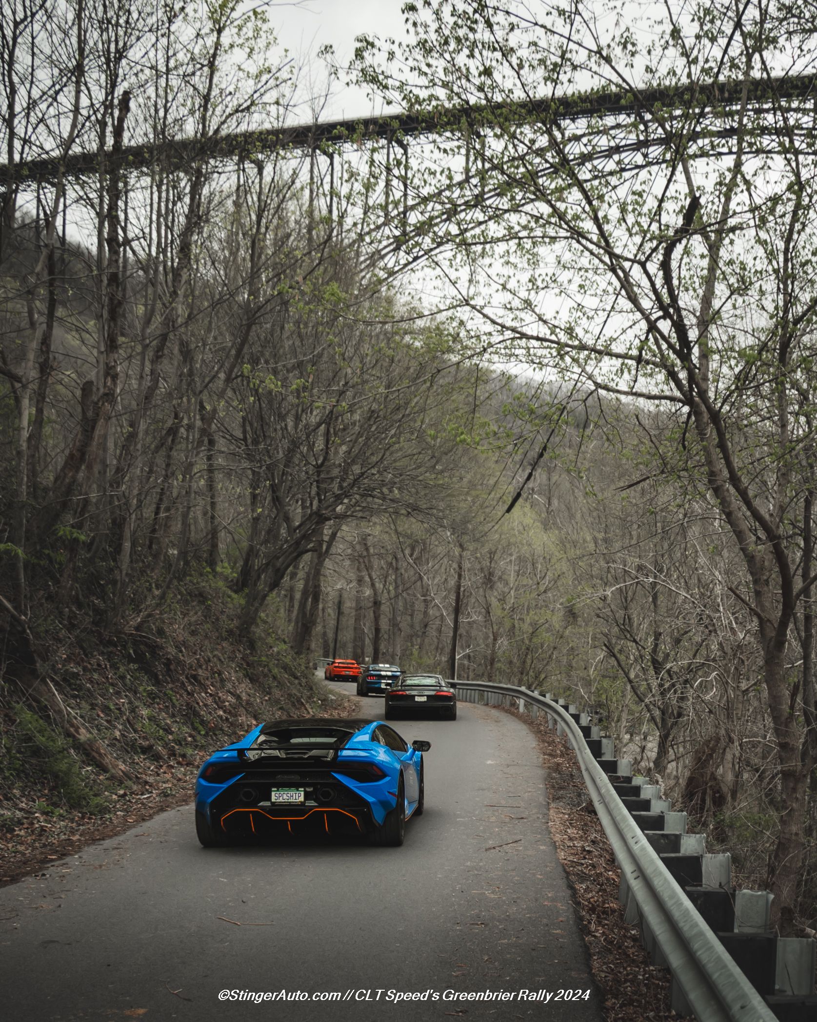 A blue lamborghini is driving down a road with other cars