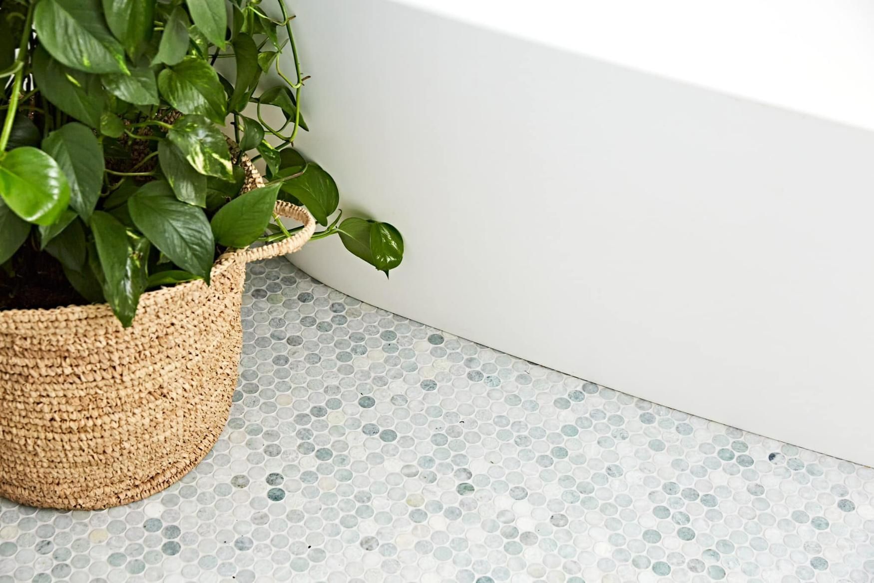 A Potted Plant Is Sitting on The Floor Next to A Bathtub — Peninsula Tiles in Umina Beach, NSW