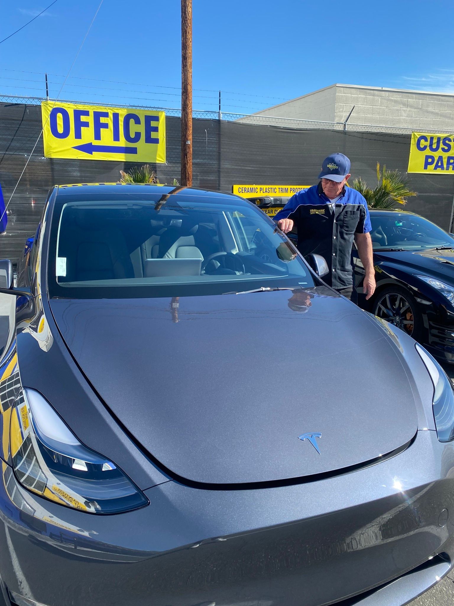 A man is fixing the windshield of a tesla model 3