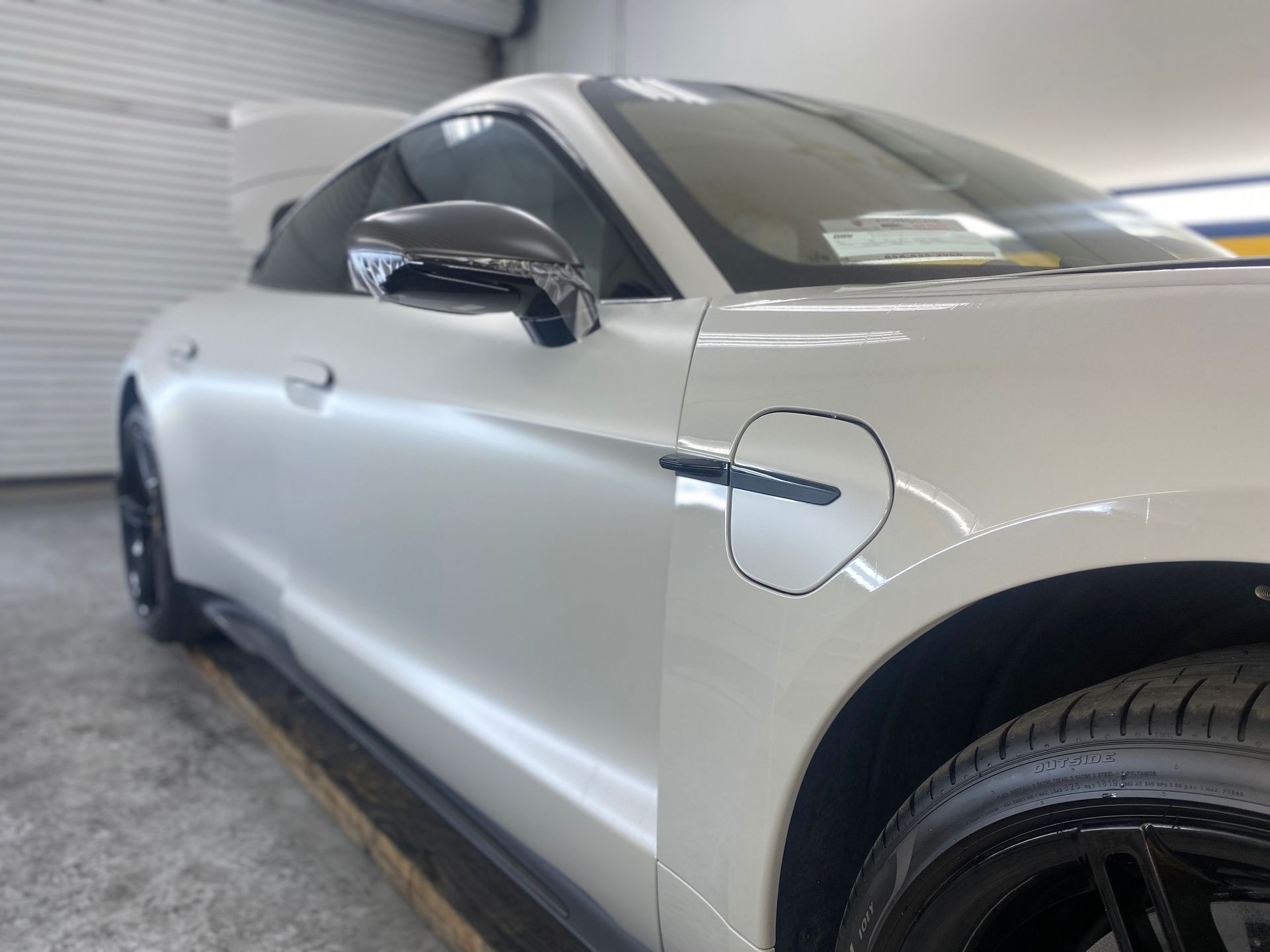 A white ford mustang is parked in a garage.