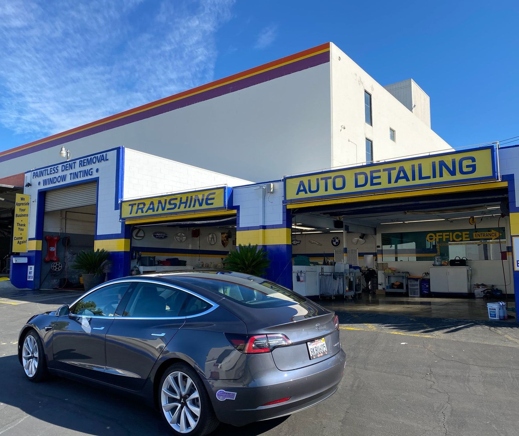 A man is fixing the windshield of a tesla model 3